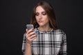 Sad teen being victim of cyber bullying online sitting on a couch in the living room at Royalty Free Stock Photo