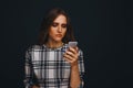 Sad teen being victim of cyber bullying online sitting on a couch in the living room at Royalty Free Stock Photo