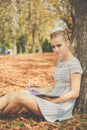 Sad teen girl in autumn park with notebook Royalty Free Stock Photo