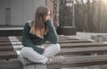 Sad teen girl on a bench in the park. Single girl outdoor. Lonely sad girl Royalty Free Stock Photo