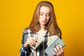 Sad teen girl with gray wallet full of money dollars Royalty Free Stock Photo