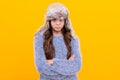 sad teen girl wear earflap hat on yellow background, season fashion