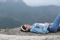 Sad teen listening to music alone in the mountain