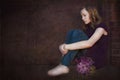 Sad teen with violet bouquet