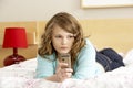Sad Teenage Girl In Bedroom With Mobile Phone Royalty Free Stock Photo
