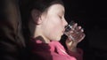 Sad teenage girl drinks water from an ailment in the cabin of plane while traveling stock footage video