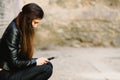 Sad teenage girl feeling lonely, looking at smartphone reading message