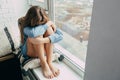 A sad teenage girl hugging her knees laid her head on them and in depression does not know what to do next. Confused and lonely Ca Royalty Free Stock Photo