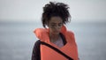 Sad teenage girl in life jacket looking distressed and lonely, disaster victim Royalty Free Stock Photo