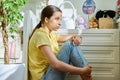 Sad teenage girl sitting on the floor at home Royalty Free Stock Photo