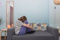 Sad teenage girl wrapping her arms around her legs on the therapy room couch during her session. Royalty Free Stock Photo