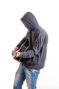 Sad teenager in black hoodie playing acoustic guitar