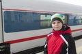 Sad teenager boy standing near train