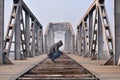 Sad teenager in depression sitting on a bridge at the sunset. Royalty Free Stock Photo