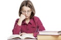 Sad teenager girl in glasses sits at a table with books, propping her head on her hand. Knowledge and education. Isolated on a