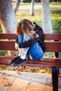 Sad teenager girl sitting on the bench in autumn park. Crying young girl in depression Royalty Free Stock Photo