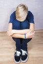 Sad teenager sits on a floor in the room Royalty Free Stock Photo