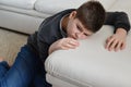 Sad teenager sitting near sofa Royalty Free Stock Photo