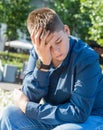 Sad teenager sitting on street Royalty Free Stock Photo