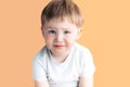 Sad, thinking. Closeup portrait headshot depressed, alone, tired child on orange background. Negative human emotion face Royalty Free Stock Photo