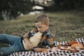 Sad thinking dreaming kid boy lies on a blanket near a river or lake