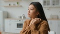 Sad thoughtful Asian chinese korean single woman pensive looking away thinking of grief problems sit lonely in domestic Royalty Free Stock Photo