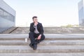 Sad, thoughtful business man sits on the steps and looks to the side Royalty Free Stock Photo