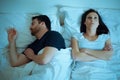 Sad and thoughtful woman awake while husband is sleeping in bed Royalty Free Stock Photo