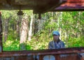 Sad thoughtful Yakut Asian girl tourist with glasses looking at the iron remains of the ship during the Soviet Union abandoned.