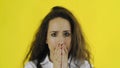 Sad thoughtful young beautiful woman standing in Studio with yellow Background.