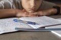 Sad tired boy sitting and looking in to books and notebooks. Education, school, learning difficulties, dyslexia concept