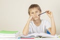 Sad tired upset child sitting at desk and doing homework at home. Education, school, learning difficulties concept Royalty Free Stock Photo