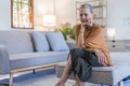 Sad tired ill sick lonely disappointed caucasian old elderly senior woman grandmother sitting on the sofa couch Royalty Free Stock Photo