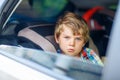 Sad tired kid boy sitting in car during traffic jam Royalty Free Stock Photo