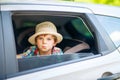 Sad tired kid boy sitting in car during traffic jam Royalty Free Stock Photo