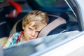 Sad tired kid boy sitting in car during traffic jam Royalty Free Stock Photo