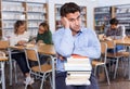 Sad tired man sitting in library Royalty Free Stock Photo