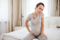 Sad tired pregnant young woman sitting on bed Royalty Free Stock Photo