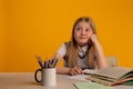 Sad and tired toddler sitting at the desk and doing homework. Royalty Free Stock Photo