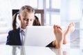 Sad and tired young beautiful  business girl working in office with bare feet up. Selective focus on feet Royalty Free Stock Photo