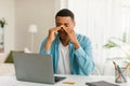 Sad tired young black male resting from work with laptop, suffering from migraine Royalty Free Stock Photo