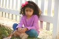 Sad toddler kid girl portrait in a park fence