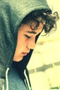 Sad troubled school boy teenager wearing a hood - close up in instant photo style with subdued colors Royalty Free Stock Photo