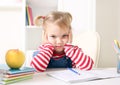 Sad unhappy kid sitting at table and lerning.Little girl study concept bored and tired expression Royalty Free Stock Photo