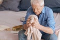 Sad unhappy man holding his wifes knitted jacked