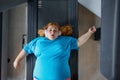 Sad unhappy overweight woman feeling pain while training at wall for posture correction Royalty Free Stock Photo