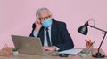 Sad unhappy senior office businessman putting on face medical mask to prevent respiratory infection Royalty Free Stock Photo