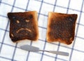 Sad and unhappy smiley made from toasted bread with knife. Royalty Free Stock Photo