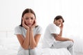 Sad unhappy upset resentful european young wife ignores husband after quarrel, sitting in bed Royalty Free Stock Photo