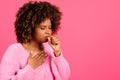 Sad unhappy young black curly female in casual coughing, suffering from sore throat Royalty Free Stock Photo